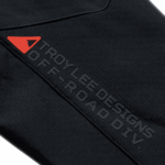 Close-up of a black Troy Lee Designs SCOUT Softshell Jacket with logo and branding details.